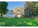 Front exterior of home with two car garage, mature trees, and a lush green lawn at 15612 Howell Park Ln, Tampa, FL 33625