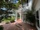 Charming exterior with brick patio and classic columns, with a view of the lake and landscaping at 15612 Howell Park Ln, Tampa, FL 33625