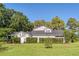 Spacious backyard featuring a neatly manicured lawn and mature trees, providing a private and serene outdoor space at 15612 Howell Park Ln, Tampa, FL 33625