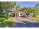Charming home featuring a covered carport with stone pillars, offering both style and functionality in a serene setting at 15612 Howell Park Ln, Tampa, FL 33625