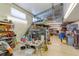 A cluttered garage featuring a high ceiling and a stairway to a storage loft at 15612 Howell Park Ln, Tampa, FL 33625