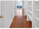 Hallway with hardwood floors and built in shelving with a view of a room with a window in the background at 15612 Howell Park Ln, Tampa, FL 33625