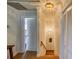 Hallway featuring white walls, wood flooring, and natural light, leading to stairs and doorways at 15612 Howell Park Ln, Tampa, FL 33625
