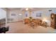 A bright living room featuring tan carpeting, ceiling fan, and comfortable seating at 15612 Howell Park Ln, Tampa, FL 33625