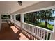 Spacious porch with a swing overlooking lush landscaping and serene lake views at 15612 Howell Park Ln, Tampa, FL 33625