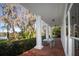 Covered porch with brick flooring, white columns, and lake views at 15612 Howell Park Ln, Tampa, FL 33625