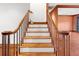 Staircase with hardwood steps, oak handrail, and white risers leading to the upper level at 15612 Howell Park Ln, Tampa, FL 33625