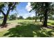 Beautiful backyard with lush green grass and mature trees overlooking a serene golf course at 16106 Worlington Pl, Odessa, FL 33556