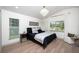 Serene bedroom with a vaulted ceiling, modern chandelier, and windows overlooking the landscaped backyard at 16106 Worlington Pl, Odessa, FL 33556