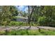 Side view of home with mature trees and green landscaping at 17306 Livingston Ave, Lutz, FL 33559