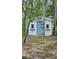 Charming backyard shed with painted blue door and trim providing storage space at 17306 Livingston Ave, Lutz, FL 33559
