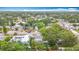 Aerial view of the home in a neighborhood surrounded by green trees under a cloudy sky at 1737 Prince Philip St, Clearwater, FL 33755