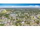 Wide aerial view showcasing a verdant neighborhood with a pond and an airport in the background at 1737 Prince Philip St, Clearwater, FL 33755