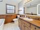 Bathroom with wood paneled half walls, a white-tiled floor, and a wood vanity with a white sink at 1737 Prince Philip St, Clearwater, FL 33755