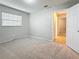 Bedroom with neutral carpet, light gray walls, a window, and an open door to the hallway at 1737 Prince Philip St, Clearwater, FL 33755