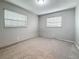 Cozy bedroom featuring neutral carpeting, light gray walls, and two windows for natural light at 1737 Prince Philip St, Clearwater, FL 33755