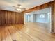 Den with wooden paneling, hardwood floors, and ceiling fan, showing a view into the living room at 1737 Prince Philip St, Clearwater, FL 33755