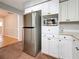 Kitchen featuring stainless steel refrigerator and microwave with white cabinetry at 1737 Prince Philip St, Clearwater, FL 33755