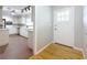 Bright kitchen with white cabinets and appliances and a view into a secondary space with hardwood flooring at 1737 Prince Philip St, Clearwater, FL 33755