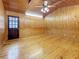 Living room featuring wood paneling on the walls, ceiling, and wainscoting, with hardwood floors at 1737 Prince Philip St, Clearwater, FL 33755