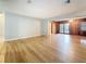 A spacious living room with light gray walls and beautiful hardwood floors, showing a view into the den at 1737 Prince Philip St, Clearwater, FL 33755