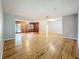 A spacious living room with light gray walls and beautiful hardwood floors, with a view into the den at 1737 Prince Philip St, Clearwater, FL 33755
