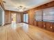 Bright living room boasts wood paneling, hardwood floors, and glass patio doors to the backyard at 1737 Prince Philip St, Clearwater, FL 33755