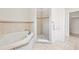 Bathroom featuring a tiled shower and separate tiled tub with decorative trim work at 17817 Gulf Blvd # A, St Petersburg, FL 33708