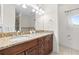 Bathroom featuring a granite countertop with double sinks and a large framed mirror at 17817 Gulf Blvd # A, St Petersburg, FL 33708