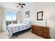 Comfortable bedroom with a twin bed, balcony access and a wooden dresser with a framed mirror at 17817 Gulf Blvd # A, St Petersburg, FL 33708