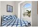 Bright bedroom featuring a large window and stylish blue and white patterned bedding at 17817 Gulf Blvd # A, St Petersburg, FL 33708