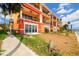 Brightly painted waterfront building featuring balconies, sliding glass doors, and lush tropical landscaping at 17817 Gulf Blvd # A, St Petersburg, FL 33708