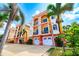 Colorful three-story townhomes with private garages and balconies, surrounded by lush palm trees and landscaping at 17817 Gulf Blvd # A, St Petersburg, FL 33708