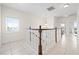 Hallway with chandelier, white and wood staircase, and views of bedroom and lake from the window at 17817 Gulf Blvd # A, St Petersburg, FL 33708