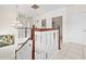Hallway with chandelier lighting, wood and white staircase, and tiled flooring at 17817 Gulf Blvd # A, St Petersburg, FL 33708