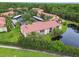 Aerial view of the community with well-maintained buildings, parking, greenery, and a scenic pond at 1801 E Lake Rd # 20 G, Palm Harbor, FL 34685
