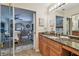 Open bathroom with granite countertop vanity, wood cabinets, view to primary bedroom, and ample storage at 1801 E Lake Rd # 20 G, Palm Harbor, FL 34685