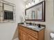 Bathroom vanity featuring granite countertops, decorative mirrors, modern fixtures and wood cabinets at 1801 E Lake Rd # 20 G, Palm Harbor, FL 34685