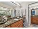 Well-appointed bathroom with a granite countertop, decorative mirror, and modern lighting at 1801 E Lake Rd # 20 G, Palm Harbor, FL 34685
