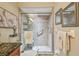 Bathroom featuring a glass-enclosed shower with gray tiles, a built-in shelf, and grab bars for accessibility at 1801 E Lake Rd # 20 G, Palm Harbor, FL 34685