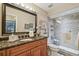 Bathroom features a granite countertop, a framed mirror, and a glass-enclosed shower with a seat at 1801 E Lake Rd # 20 G, Palm Harbor, FL 34685
