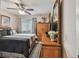 Bedroom with a ceiling fan, a large bed with black and gray bedding, and a wooden dresser with a mirror at 1801 E Lake Rd # 20 G, Palm Harbor, FL 34685