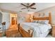 Relaxing bedroom with a view to the bathroom features a wooden bed frame and a ceiling fan at 1801 E Lake Rd # 20 G, Palm Harbor, FL 34685