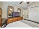 Bedroom with a bed, wooden dresser with a TV, and an open doorway to a bathroom, all under a ceiling fan at 1801 E Lake Rd # 20 G, Palm Harbor, FL 34685