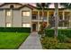 Charming condo exterior features a private entrance, updated lighting and manicured landscaping at 1801 E Lake Rd # 20 G, Palm Harbor, FL 34685