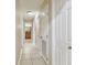 Hallway with white tile flooring and white doors, leading to various rooms including a bathroom at 1801 E Lake Rd # 20 G, Palm Harbor, FL 34685