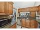 Kitchen featuring stainless steel appliances, wooden cabinets, and granite countertops with views to the dining area at 1801 E Lake Rd # 20 G, Palm Harbor, FL 34685