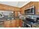 Kitchen showcases granite countertops, wooden cabinets, a stainless steel stove, and modern appliances at 1801 E Lake Rd # 20 G, Palm Harbor, FL 34685