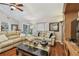 Open living room boasts wood floors, a plush sofa, and access to the outdoor patio at 1801 E Lake Rd # 20 G, Palm Harbor, FL 34685