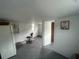 Unfinished basement offers a blank canvas, showcasing a refrigerator, office chair, and door to another room at 18133 Us Highway 41, Spring Hill, FL 34610
